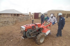 Engineer Danjuma guiding a trainee to drive the tractor
